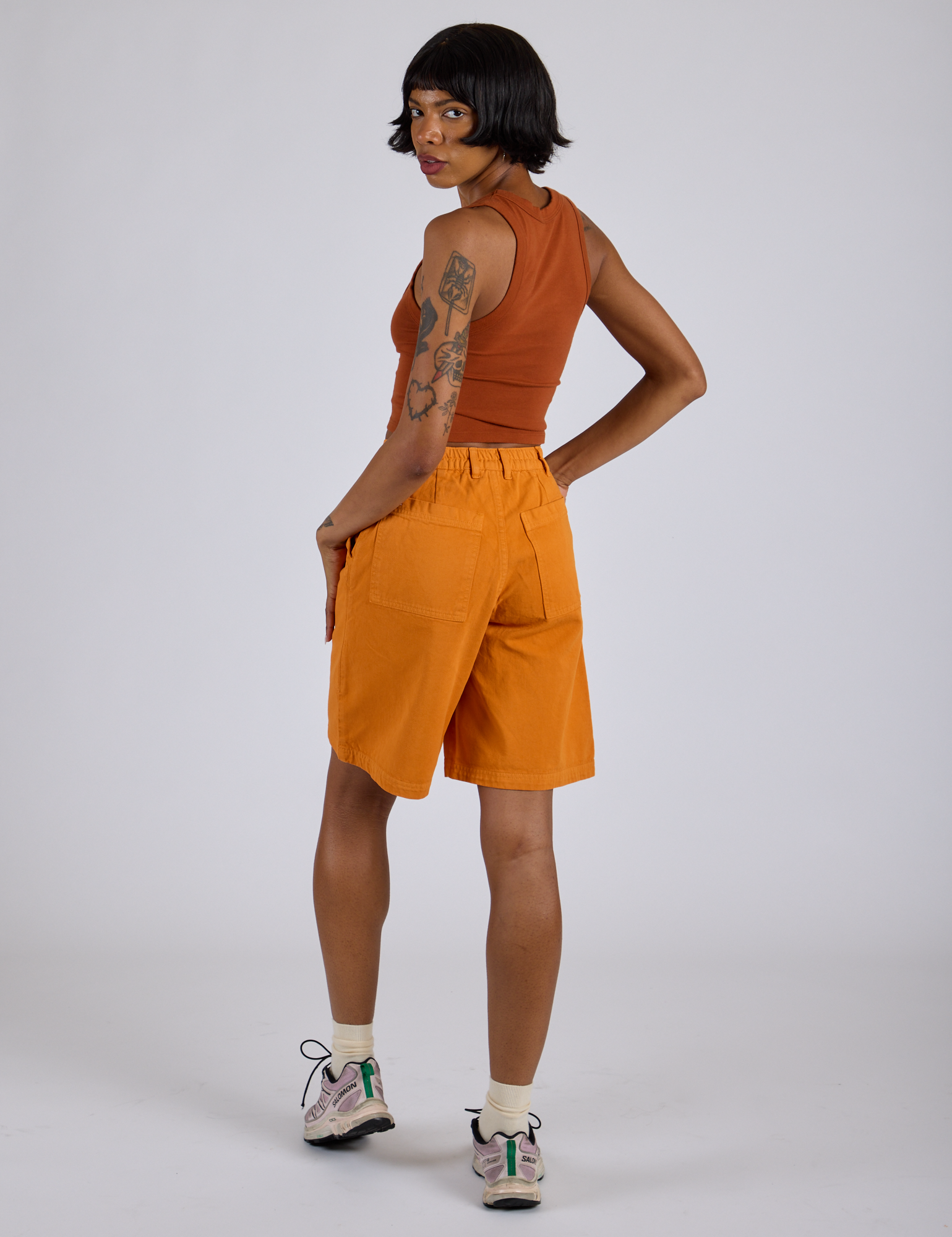 Angled back view of Longline Work Shorts in Creamsicle Orange and burnt terracotta Cropped Tank