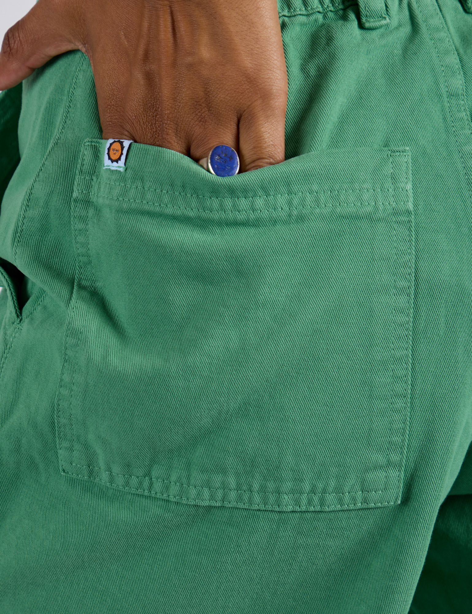 Close up of Kira's hand in the back pocket of Longline Work Shorts in Seafoam Green