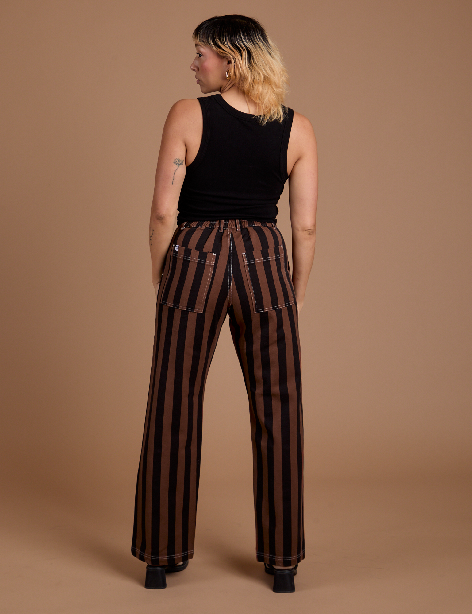 Back view of Black Stripe Work Pants in Fudgesicle Brown and black Cropped Tank on Tiara