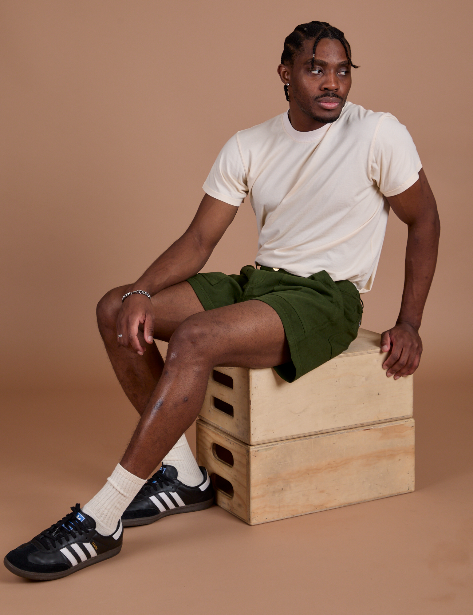 Isaac is wearing Classic Work Shorts in Evergreen and Organic Vintage Tee in Vintage Off-White