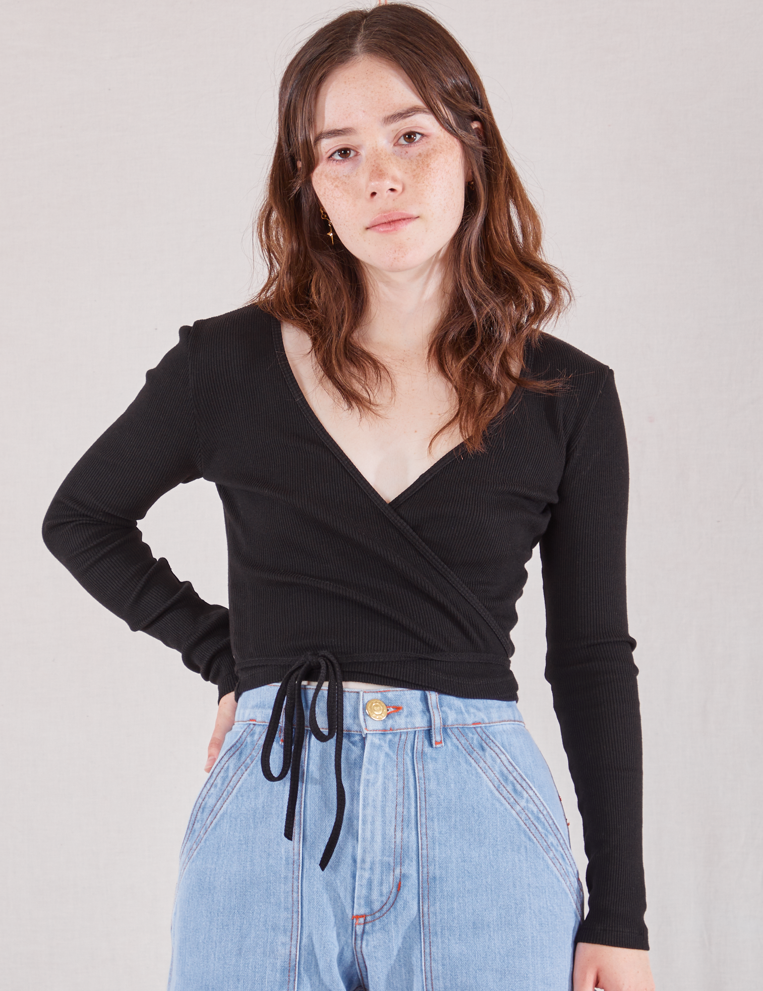 Hana is 5'3" and wearing size 1  Wrap Top in Basic Black