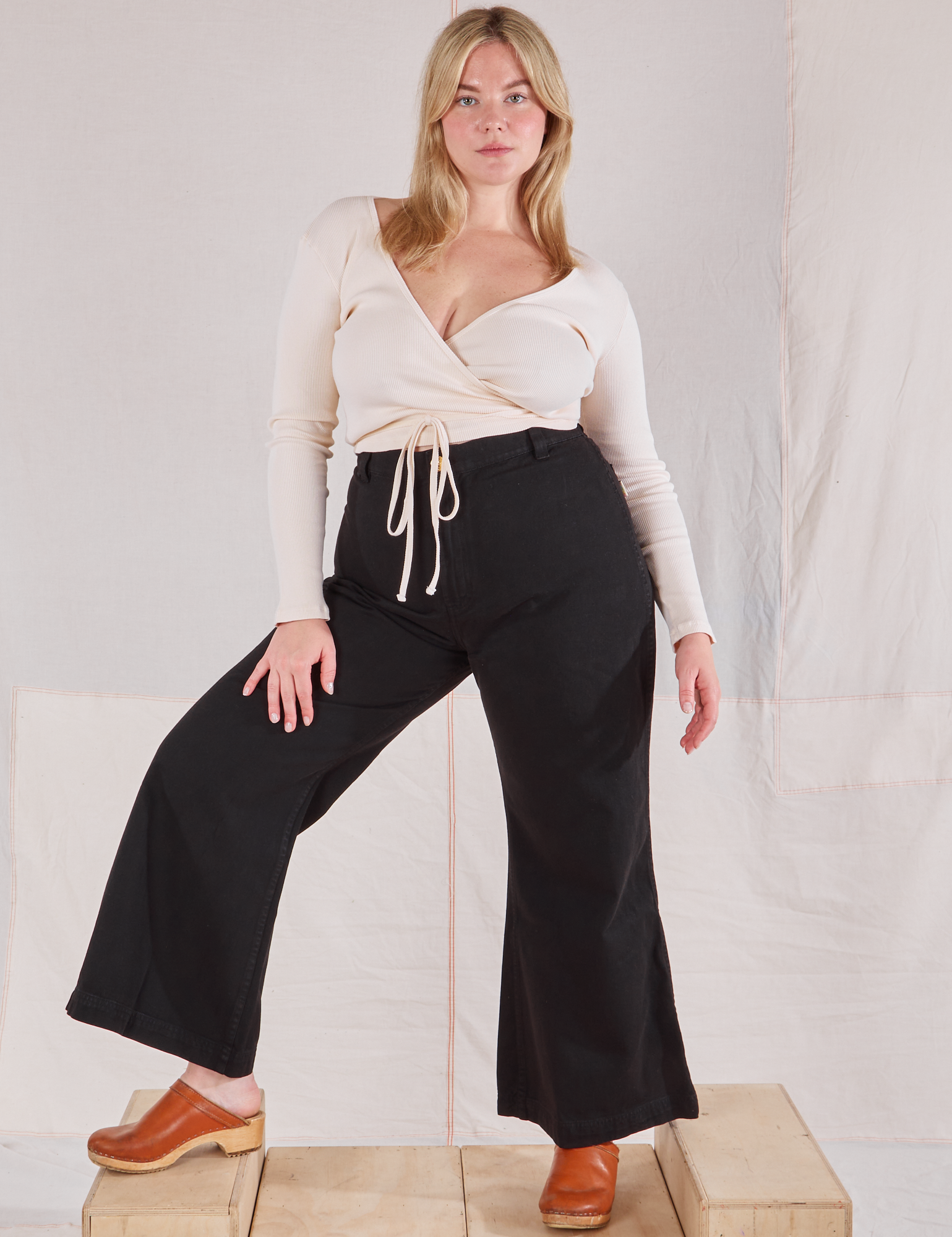 Lish is wearing Wrap Top in Vintage Tee Off-White and black Bell Bottoms