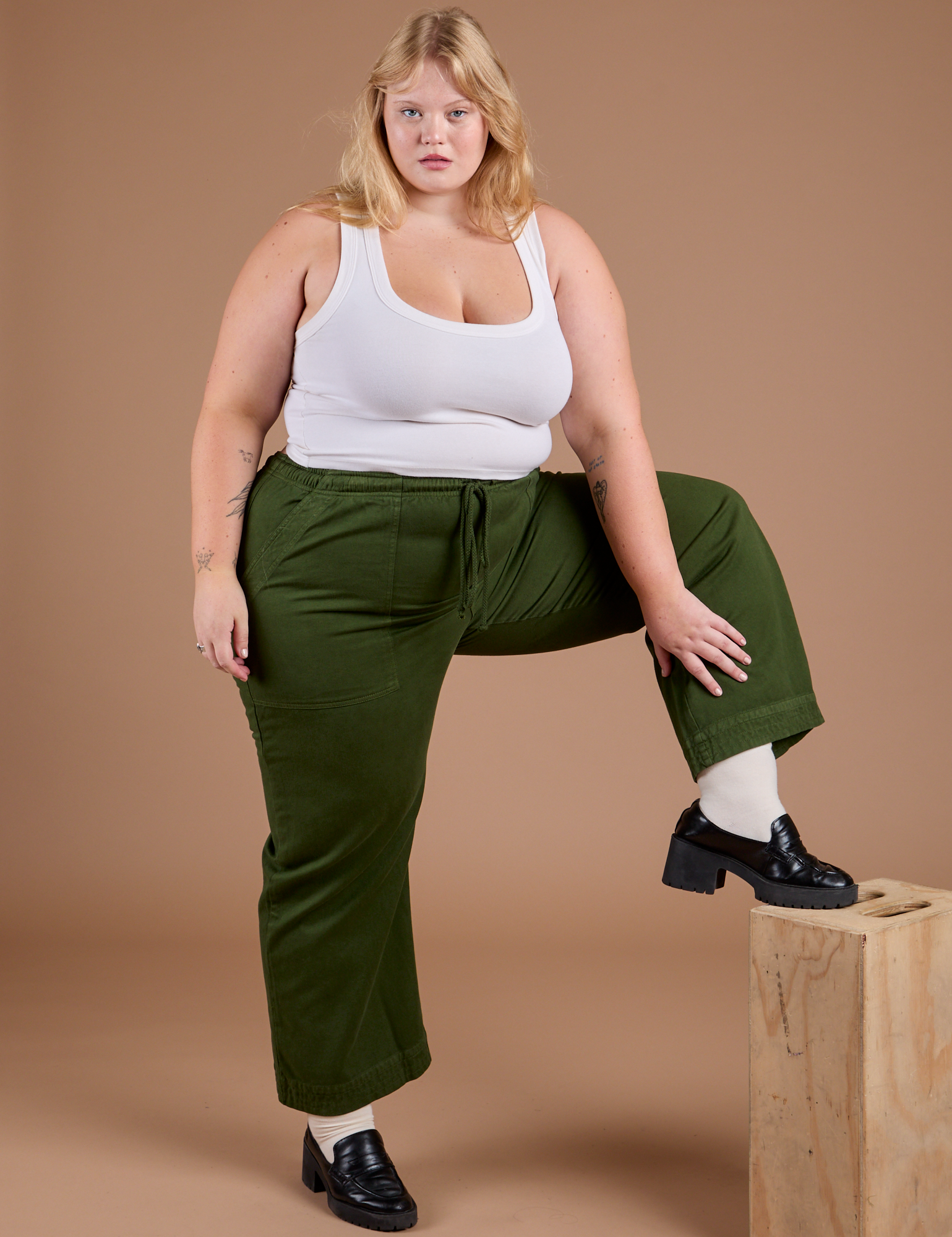 Juliet is wearing Organic Action Pants in Evergreen and vintage tee white Cropped Tank