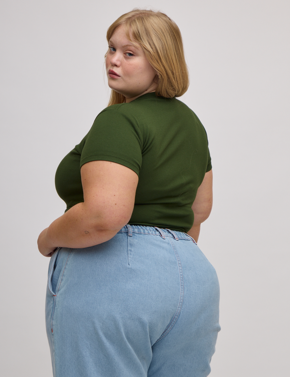 Angled back view of Baby Tee in Evergreen on Juliet