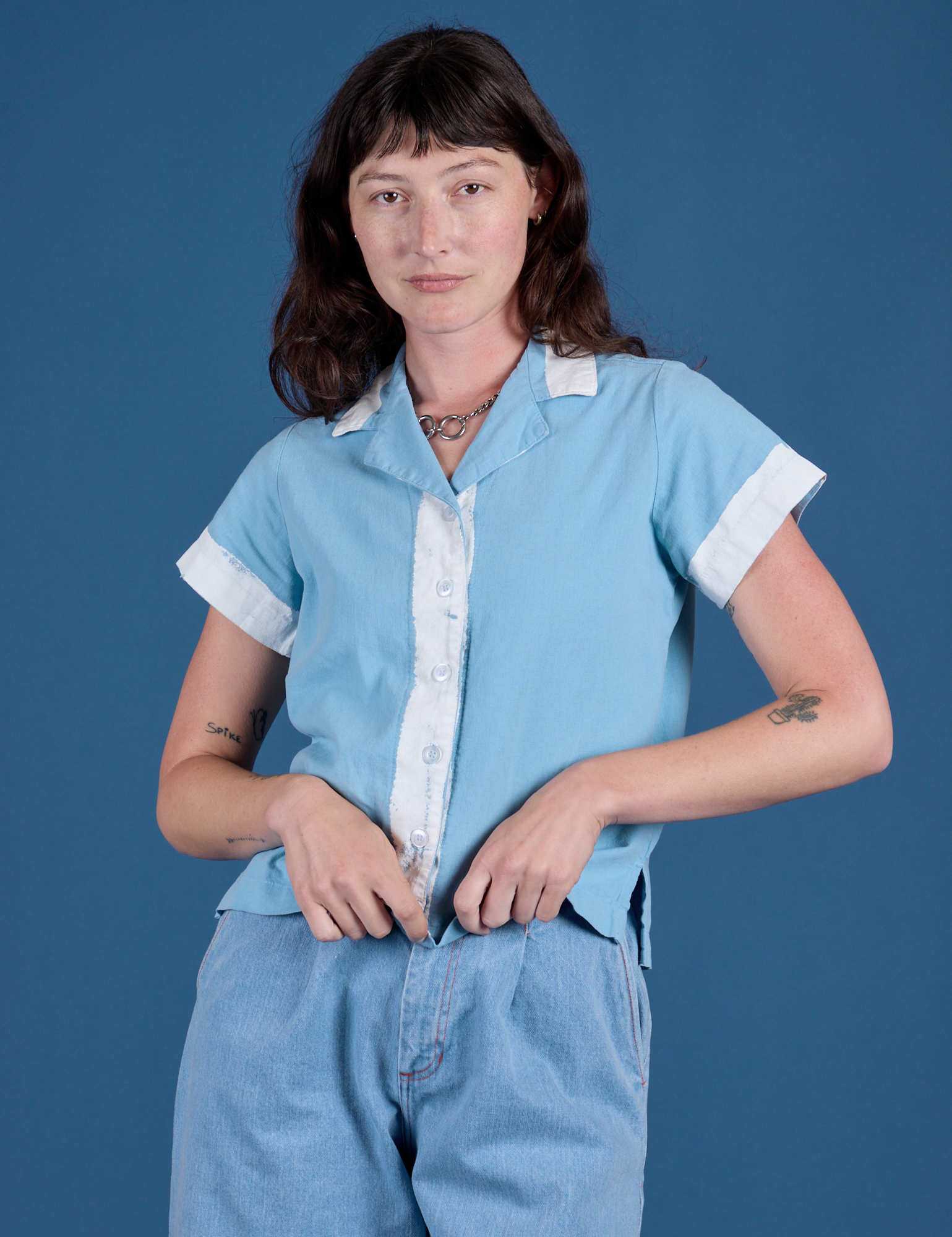 Alex is wearing a buttoned up Painted Pantry Button-Up in Baby Blue