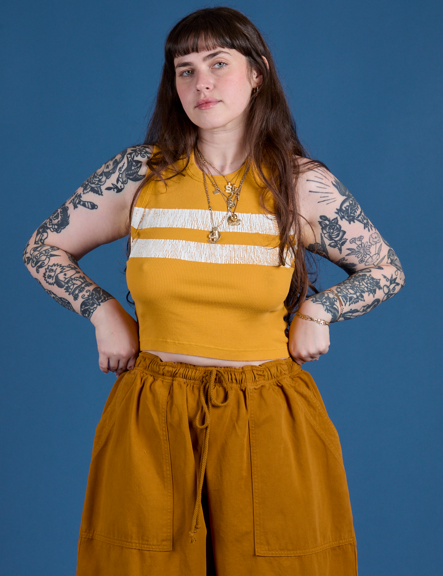 Sydney is 5’9” and wearing XXS Painted Muscle Tee in Mustard Yellow
