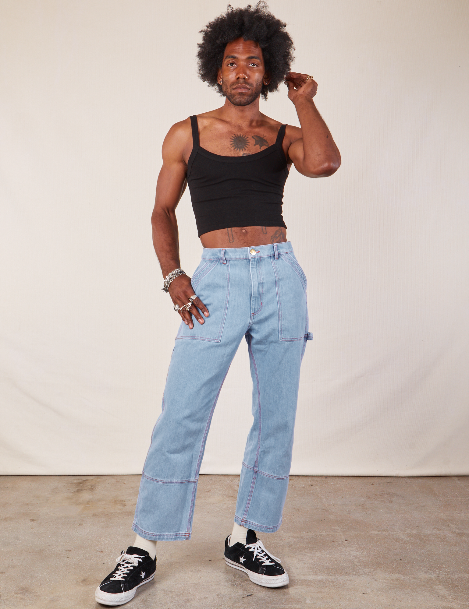 Jerrod is wearing Cropped Cami in Basic Black and light wash Carpenter Jeans