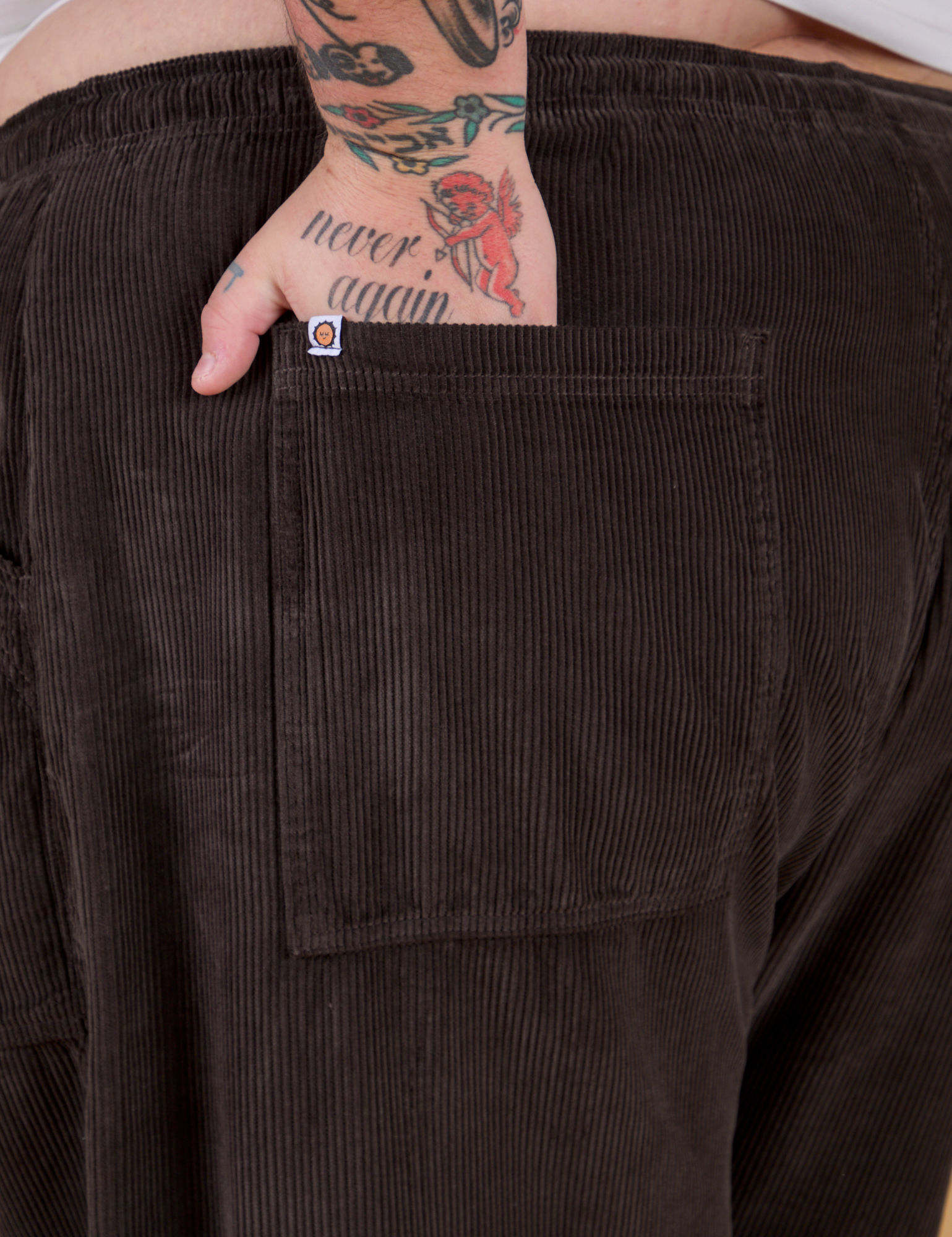 Close up of Sam's hand in the back pocket of Corduroy Drop Pocket Cargo Pants in Espresso Brown