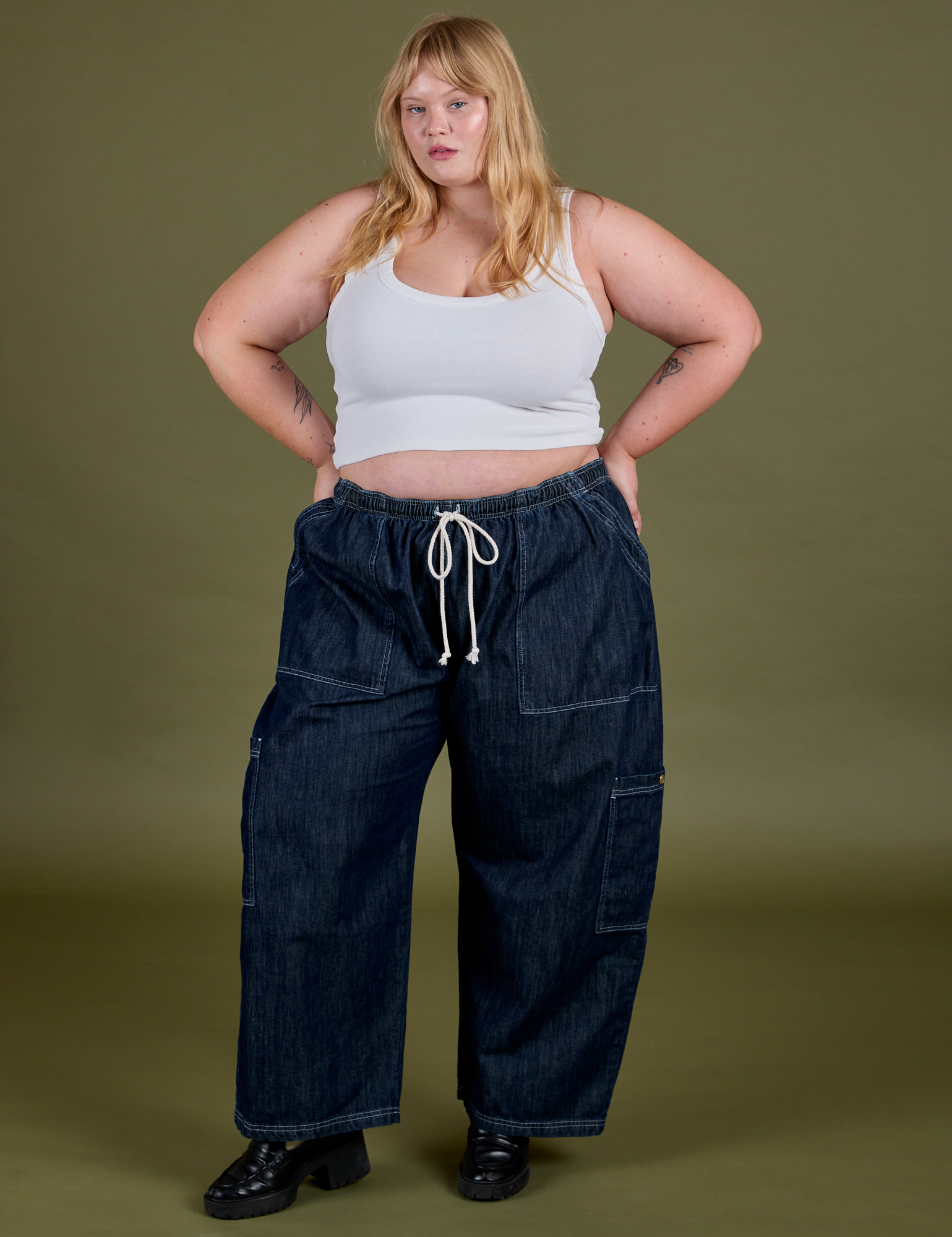 Juliet is 5’7” and wearing 2XL Denim Drop Pocket Pants in Dark Wash paired with vintage tee white Cropped Tank 