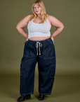 Juliet is 5’7” and wearing 2XL Denim Drop Pocket Pants in Dark Wash paired with vintage tee white Cropped Tank 