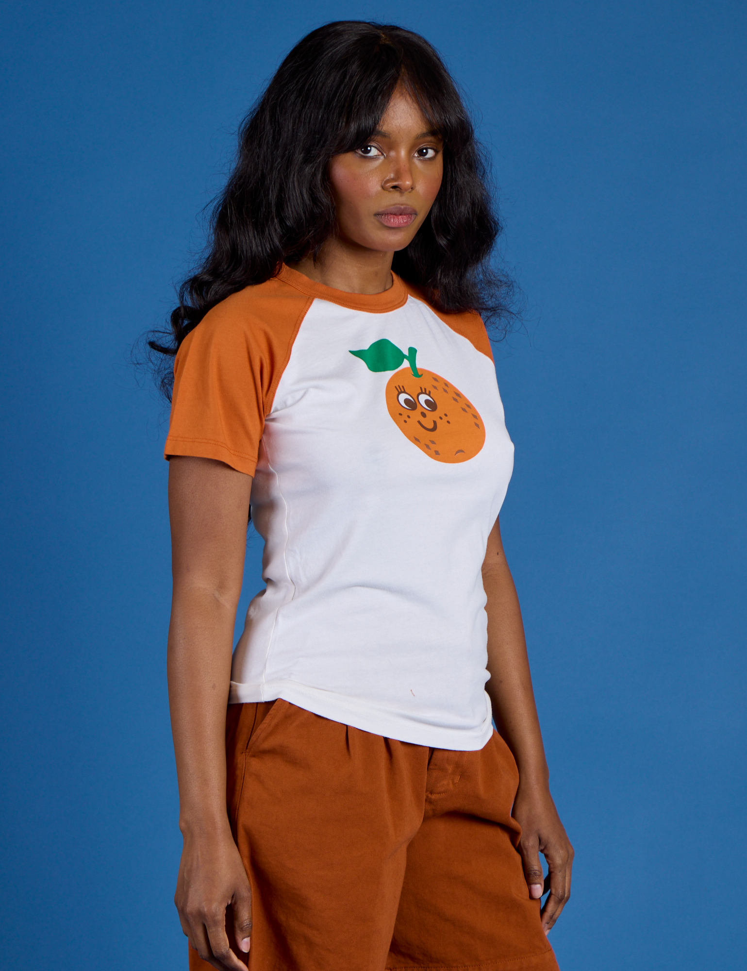 Angled front view of Produce Raglan Tee in Orange on Kandia