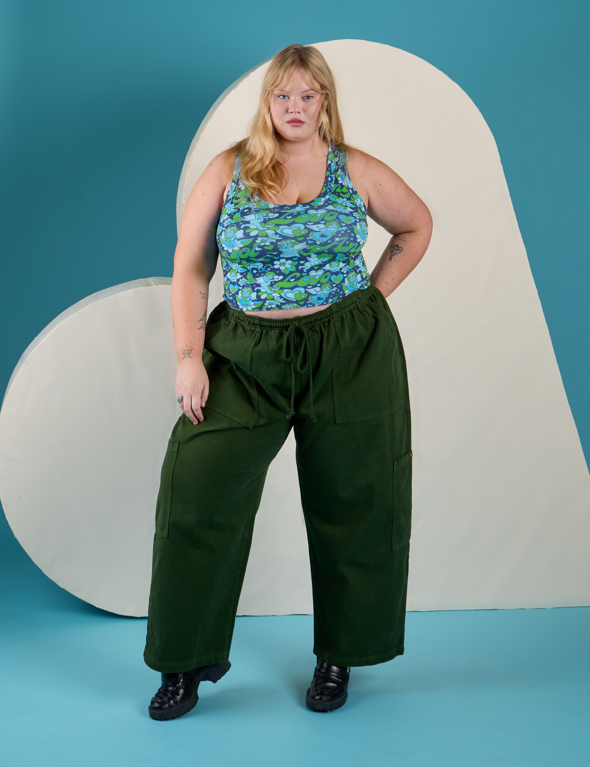 Juliet is wearing Cropped Tank Top in Angel Print and evergreen Drop Pocket Cargo Pants