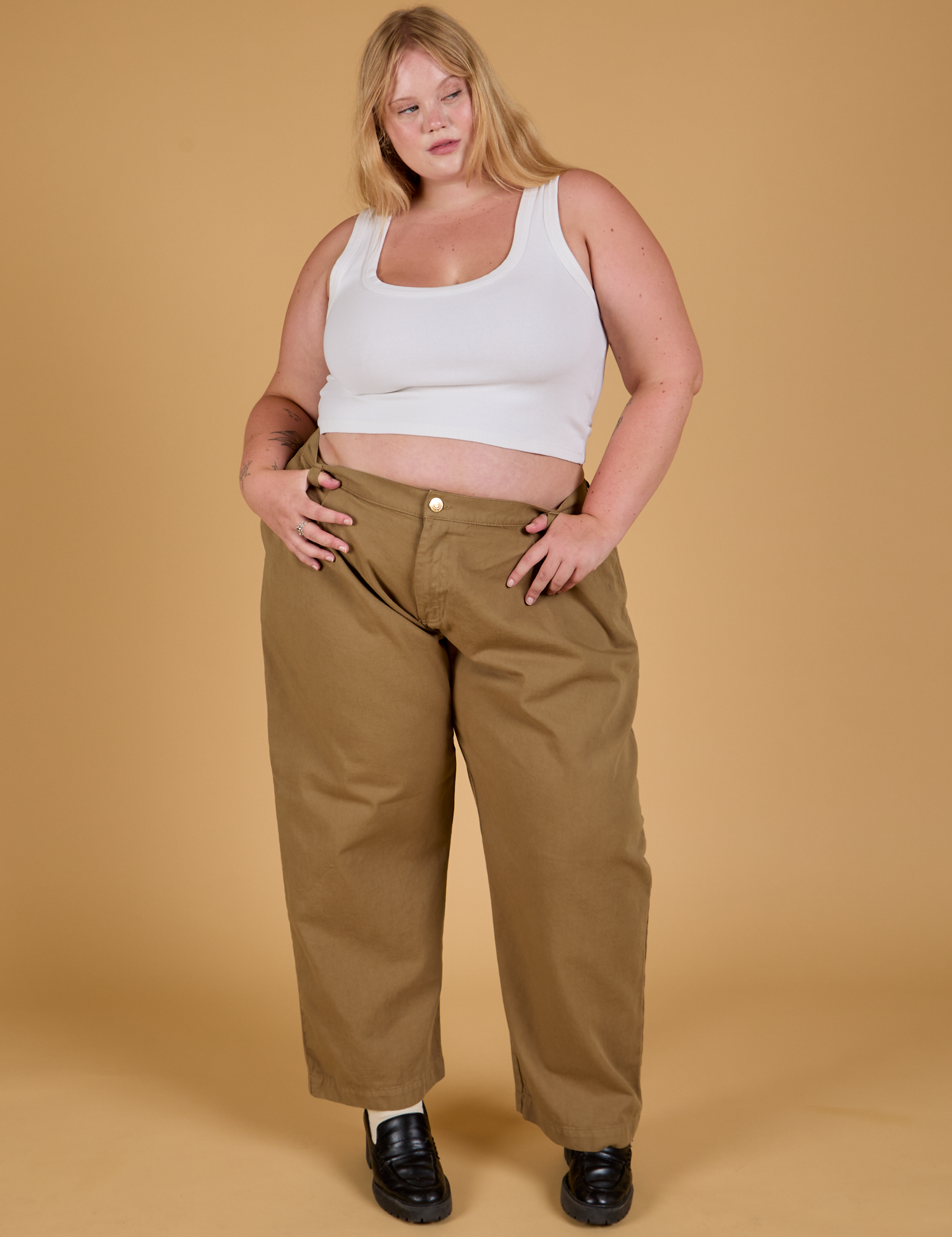 Juliet is 5'7" and wearing 1XL Baggy Mid-Rise Trousers in Desert Brown paired with a vintage tee white Cropped Tank