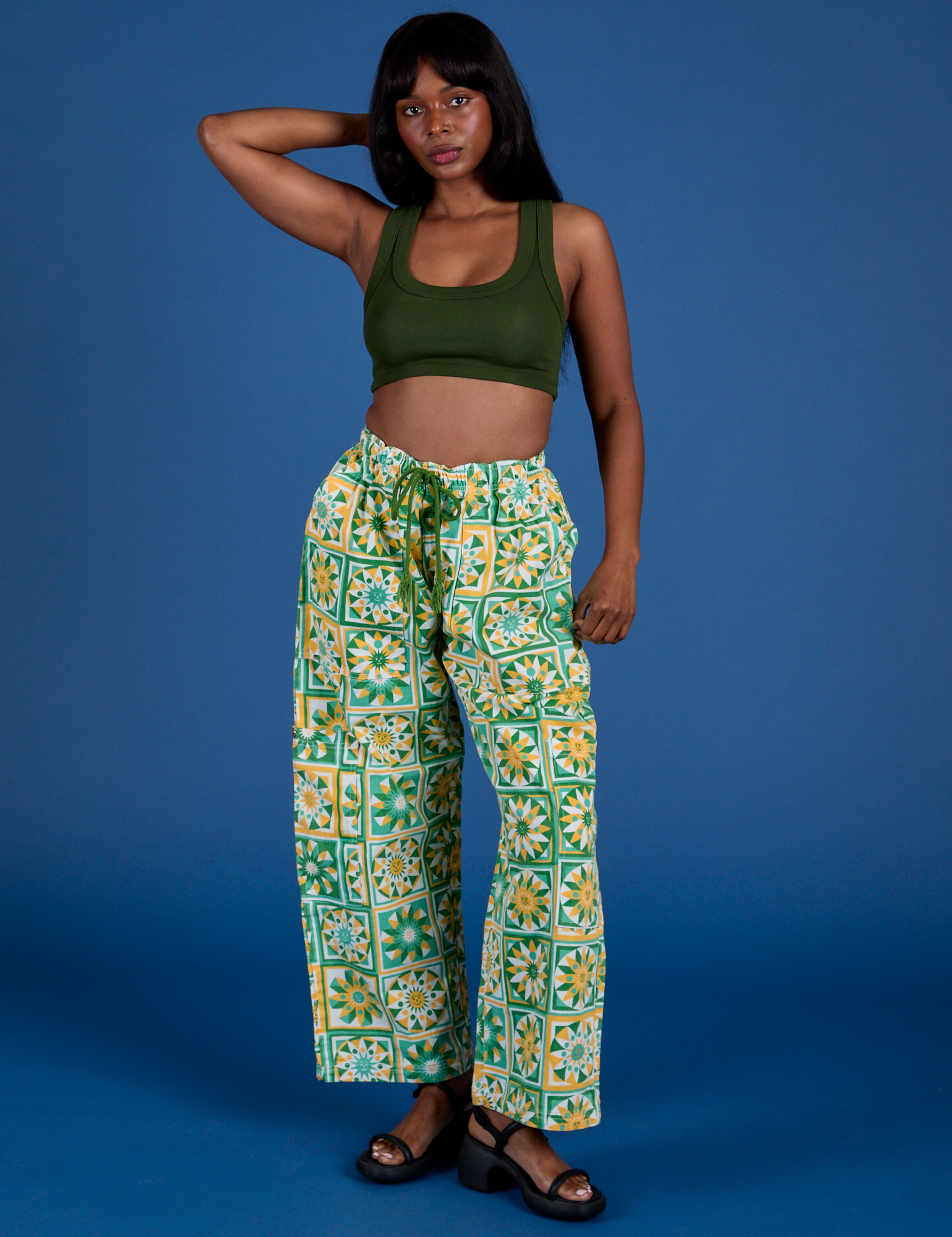 Kandia is 5’3” and wearing XS Drop Pocket Cargo Pants in Spring Quilt Print paired with evergreen Mini Tank