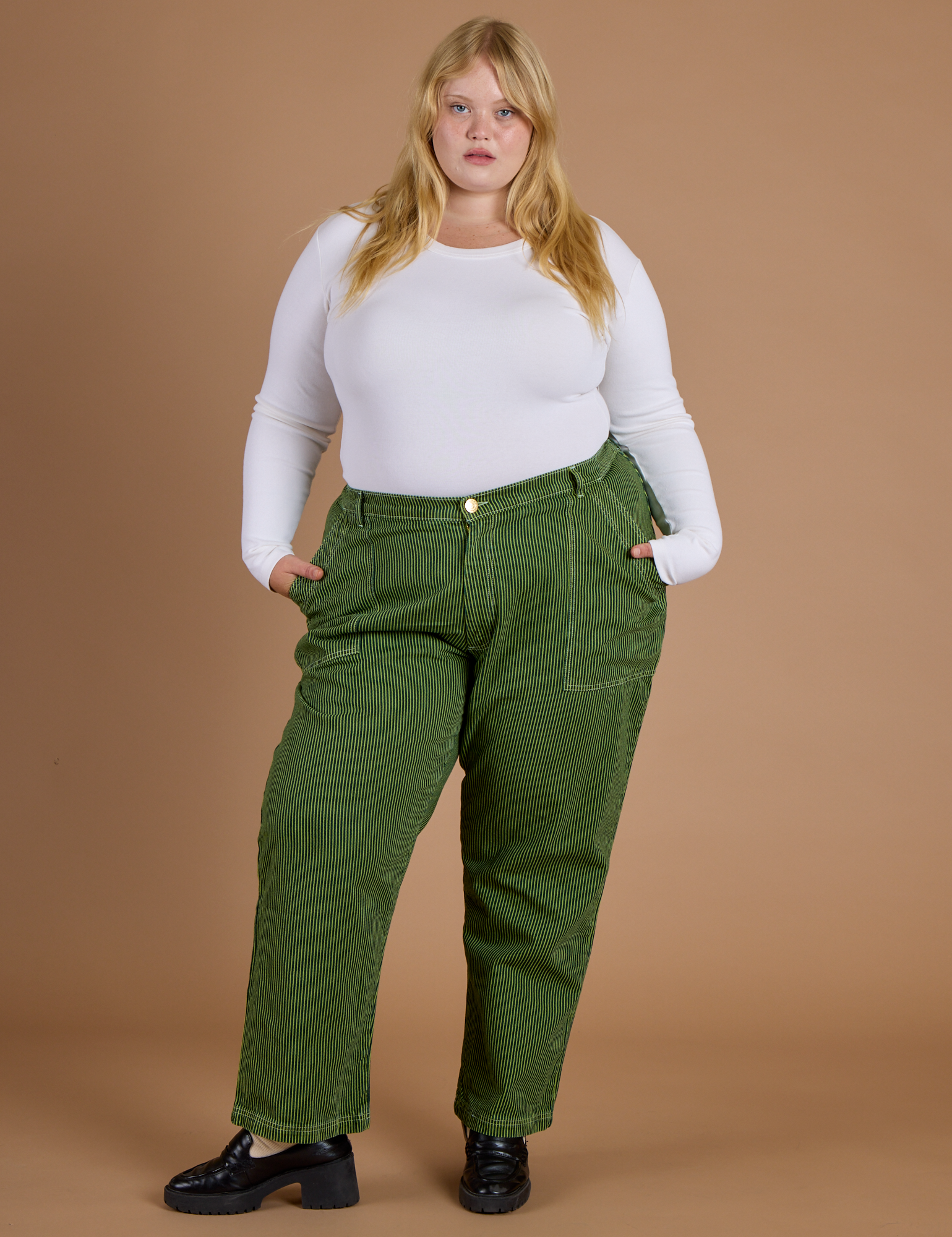Juliet is 5’7” and wearing 2XL Railroad Denim Work Pants in Gross Green Overdye paired with vintage tee white Long Sleeve Baby Tee