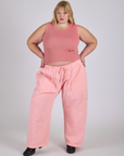 Juliet is 5’7” and wearing 2XL Drop Pocket Cargo Pants in Baby Pink paired with a Muscle Tee