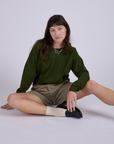 Alex is wearing Pleated Trouser Shorts in Khaki Grey and long sleeve burly tee in evergreen