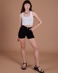 Alex is 5’8” and wearing XXS Classic Work Shorts in Basic Black paired with a Cropped Tank in Vintage Tee White