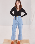 Hana is wearing Wrap Top in Basic Black and light wash Carpenter Jeans