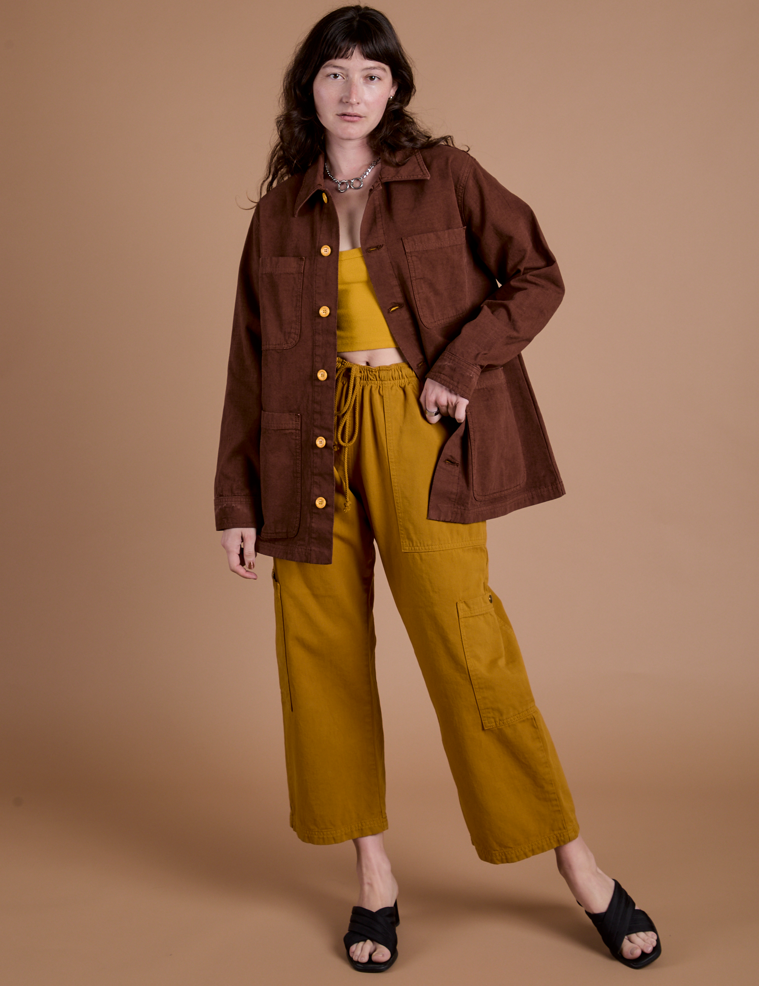 Alex is wearing Ripstop Field Coat in Fudgesicle Brown paired with spicy mustard Drop Pocket Cargo Pants