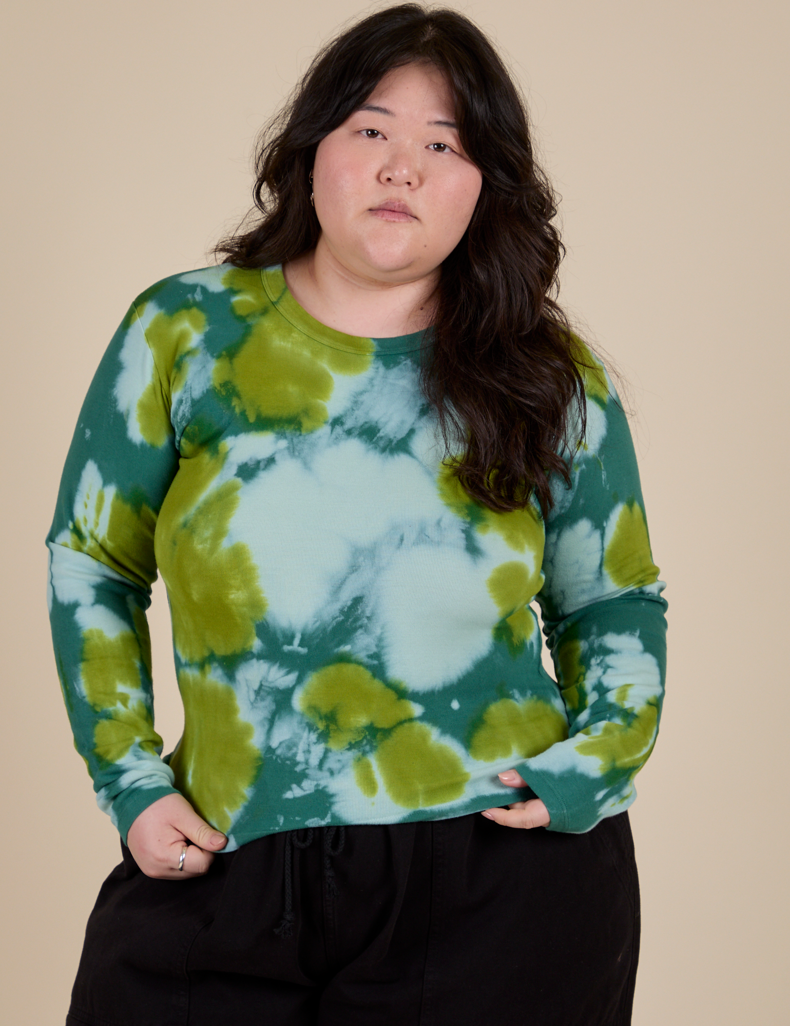 Ashley is 5’7” and wearing L Long Sleeve Baby Tee in Green Magic Waters
