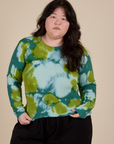 Ashley is 5’7” and wearing L Long Sleeve Baby Tee in Green Magic Waters