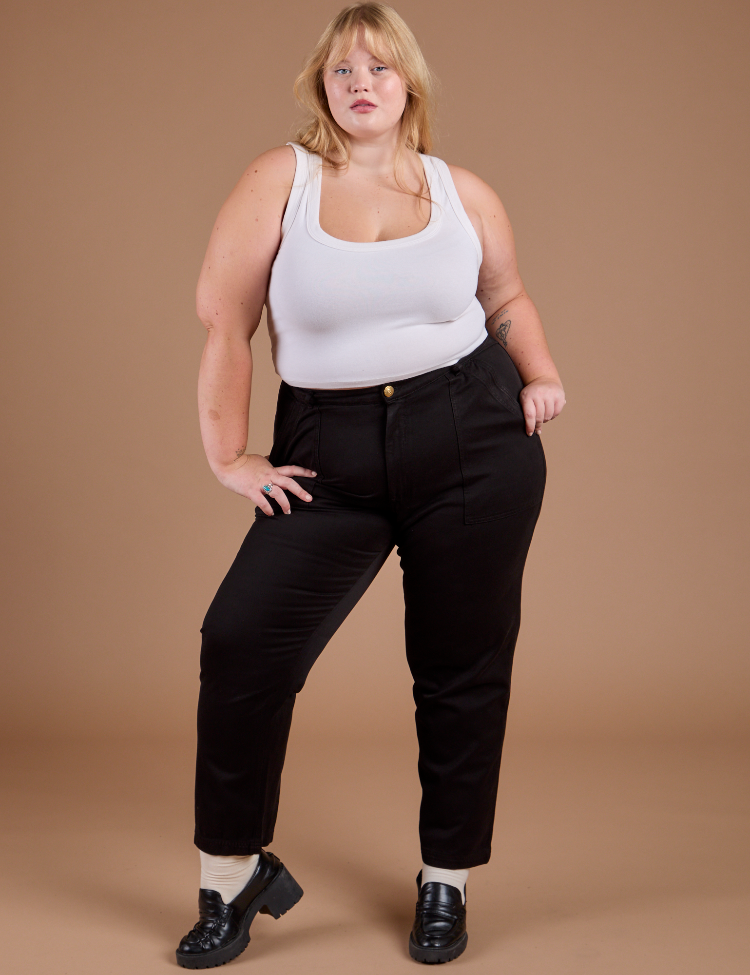 Juliet is 5'8" and wearing 1X Organic Work Pants in Basic Black paired with a vintage tee white Cropped Tank