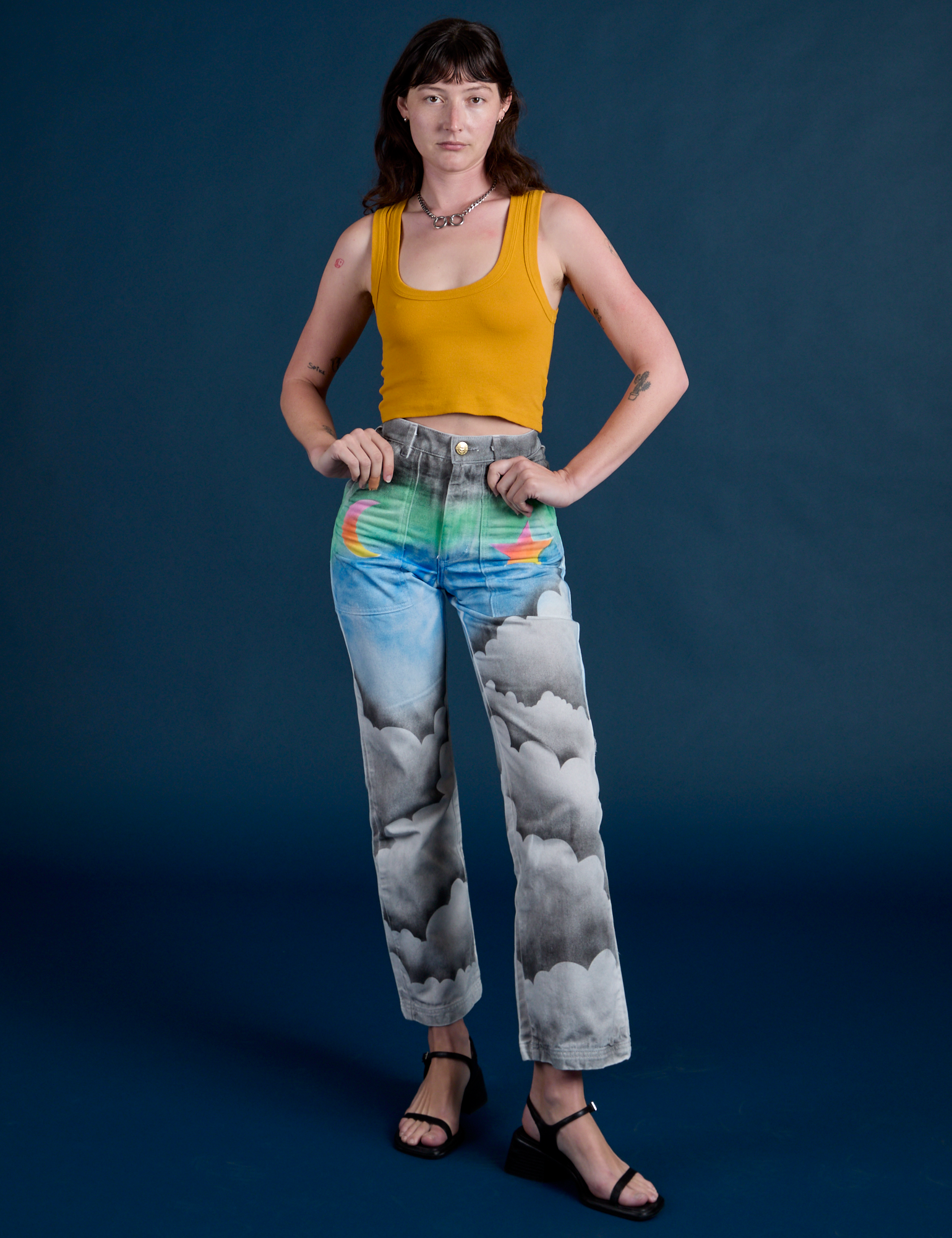 Alex is 5’8” and wearing XXS Work Pants in Night Sky Airbrush paired with mustard yellow Cropped Tank