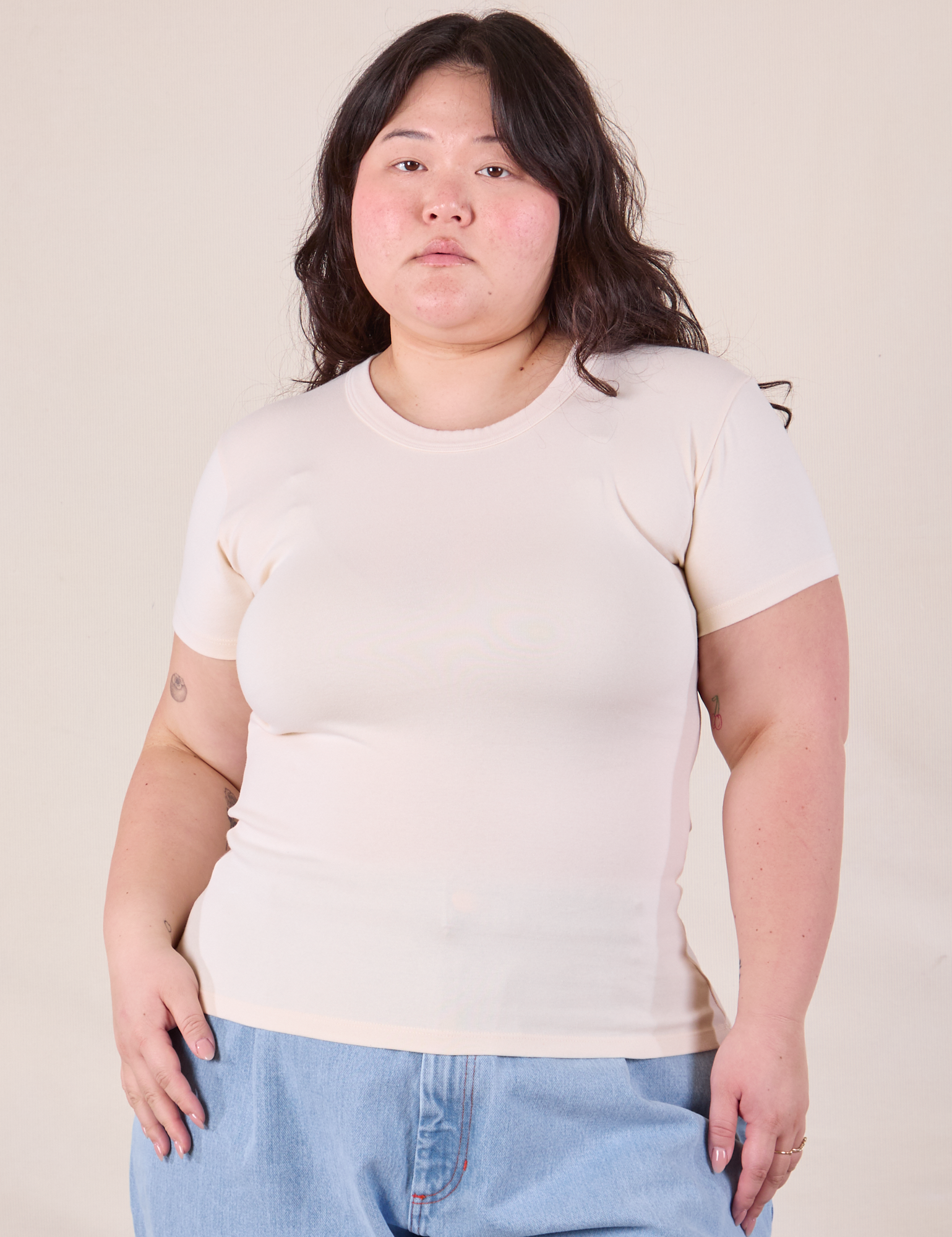 Ashley is 5'7" and wearing L Baby Tee in Vintage Tee Off-White