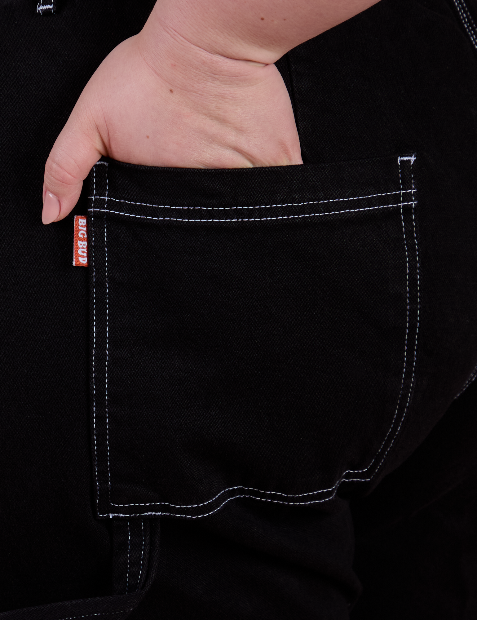 Close up of Ashley's hand in the back pocket of Carpenter Jeans in Black