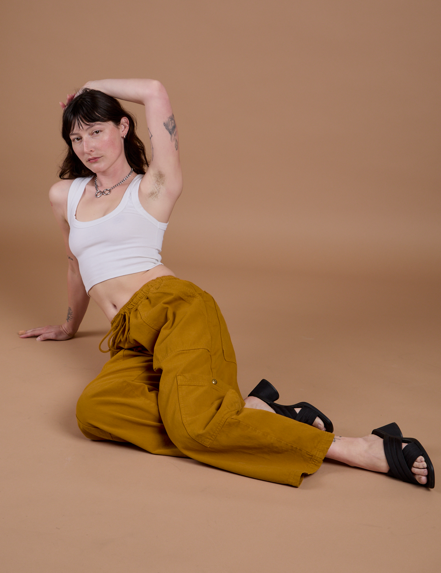 Alex is wearing Drop Pocket Cargo Pants in Spicy Mustard and vintage tee white Cropped Tank