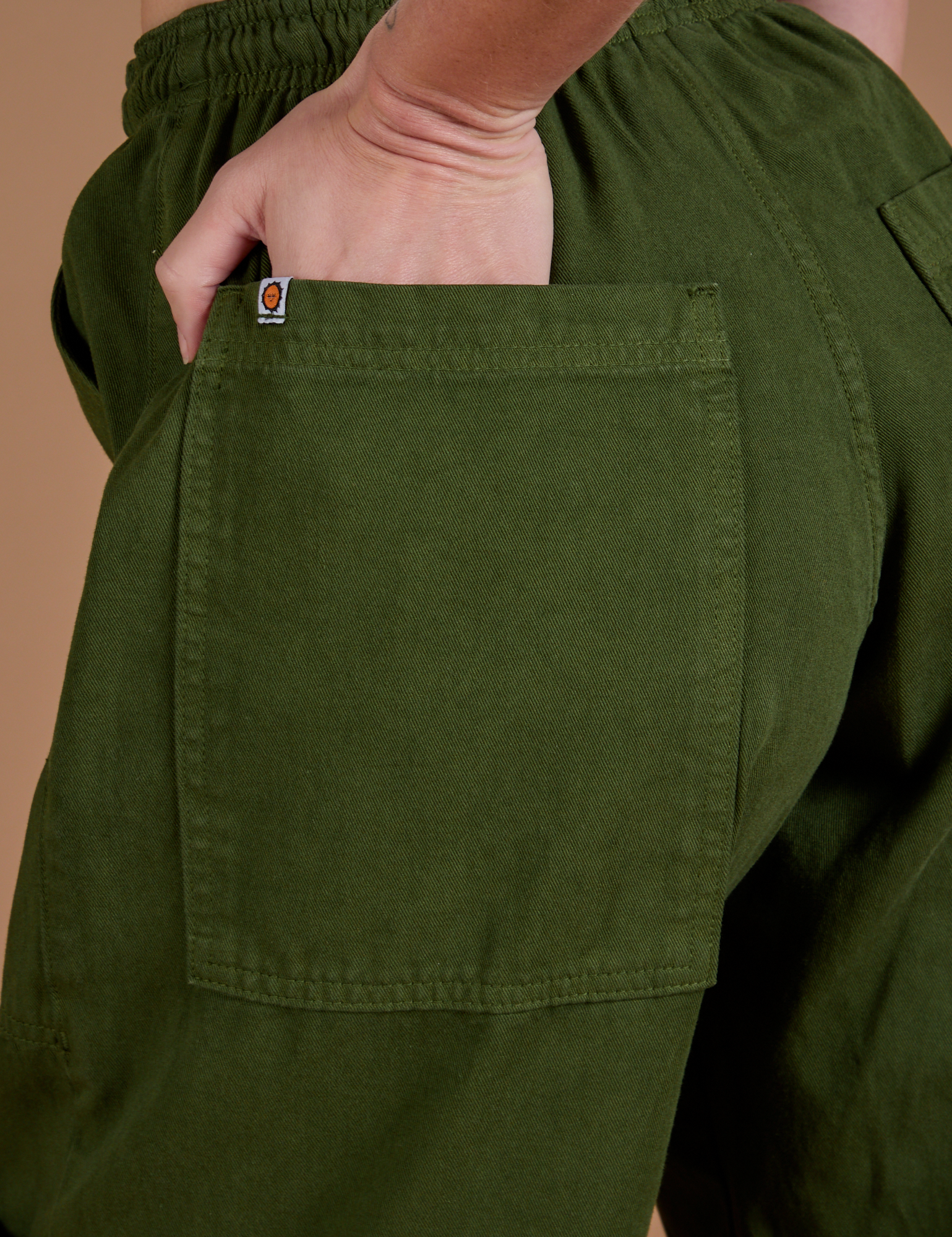 Close up of Alex's hand in the back pocket of Drop Pocket Cargo Pants in Evergreen