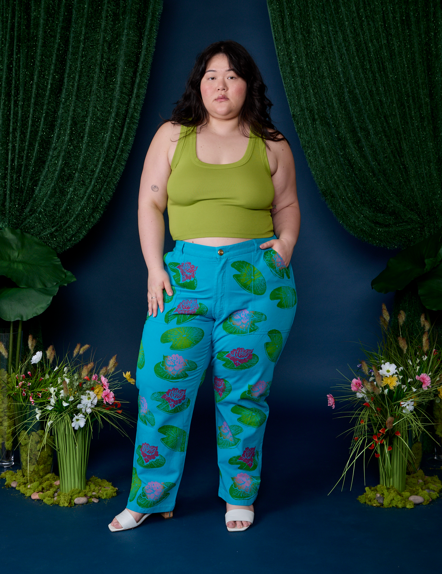 Ashley is 5'7" and wearing 1XL Paintstamped Work Pants in Lilypad paired with gross green Cropped Tank
