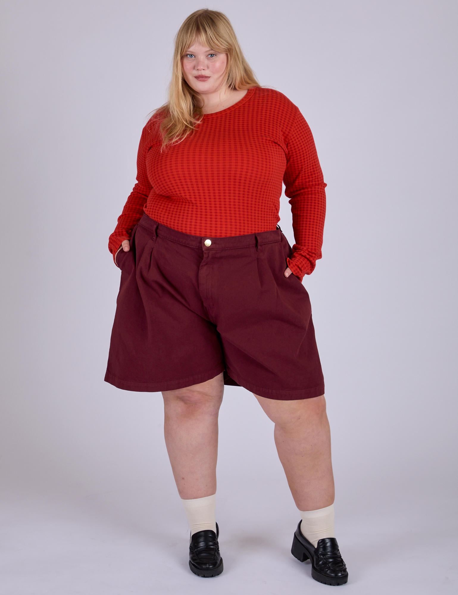 Juliet is 5’7” and wearing 2XL Pleated Trouser Shorts in Red Wine paired with Long Sleeve Gingham Baby Tee in Mustang Red