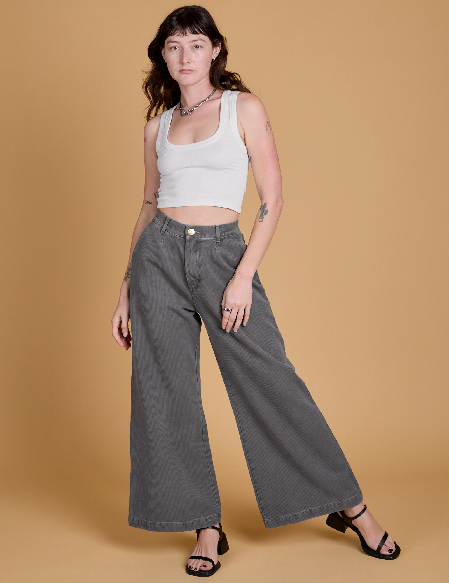 Alex is 5'8" and wearing XXS Heritage Wide Leg Trousers in Washed Grey paired with a vintage tee white Cropped Tank