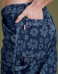 Close up of Alex's hand in the back pocket of Lazy Daisy Mid-Rise Carpenter Jeans