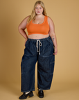 Juliet is wearing Contrast Stitch Mini Tank in Construction Orange and dark wash Denim Drop Pocket Pants