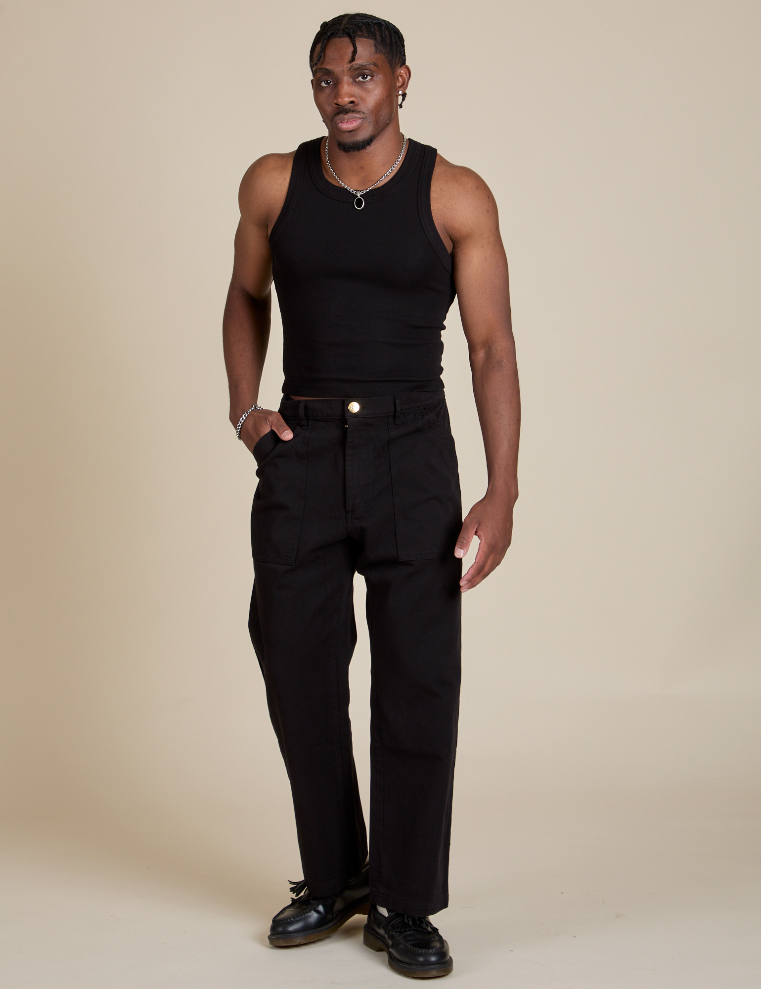 Isaac is wearing Racerback Tank in Black and Work Pants in Black