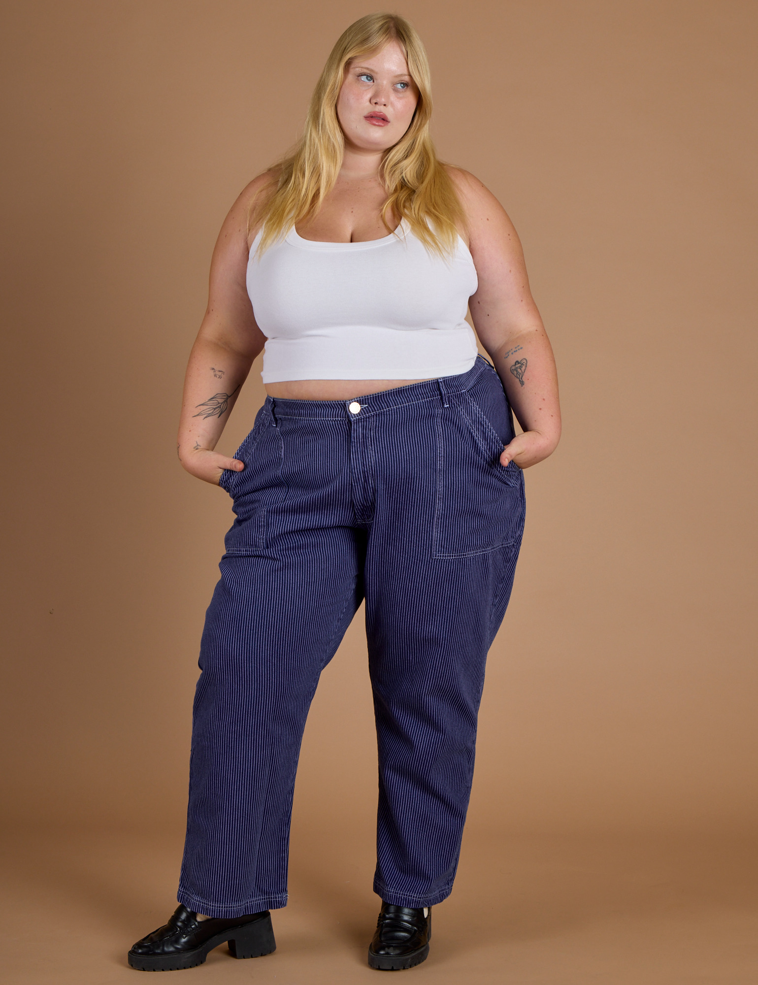 Juliet is 5’7” and wearing 2XL Railroad Denim Work Pants in Faded Grape Overdye paired with vintage tee white Cropped Tank