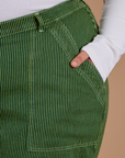 Close up of Juliet's hand in the front pocket of Railroad Denim Work Pants in Gross Green Overdye