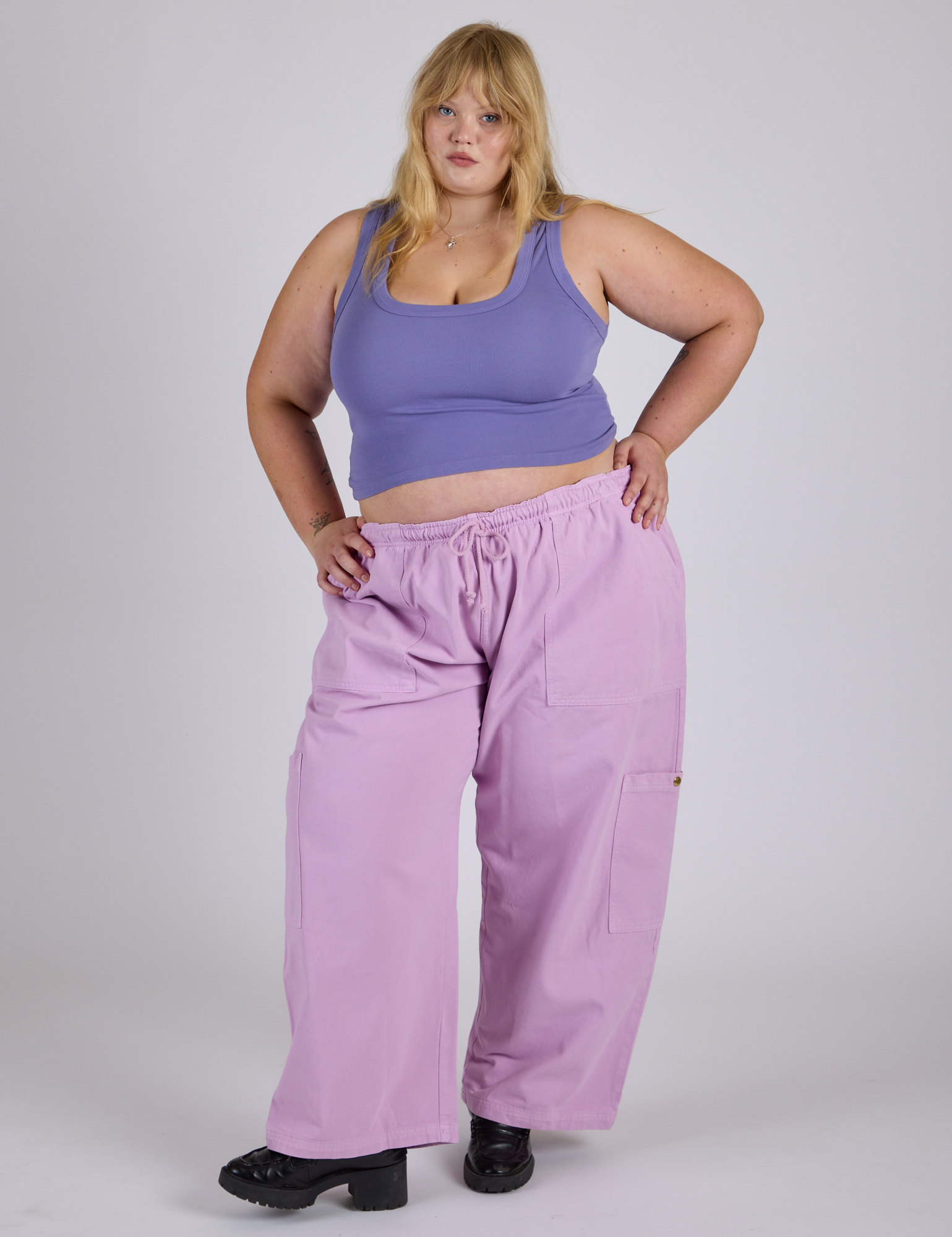 Juliet is 5’7” and wearing 2XL Drop Pocket Cargo Pants in Lilac Purple and faded grape Cropped Tank