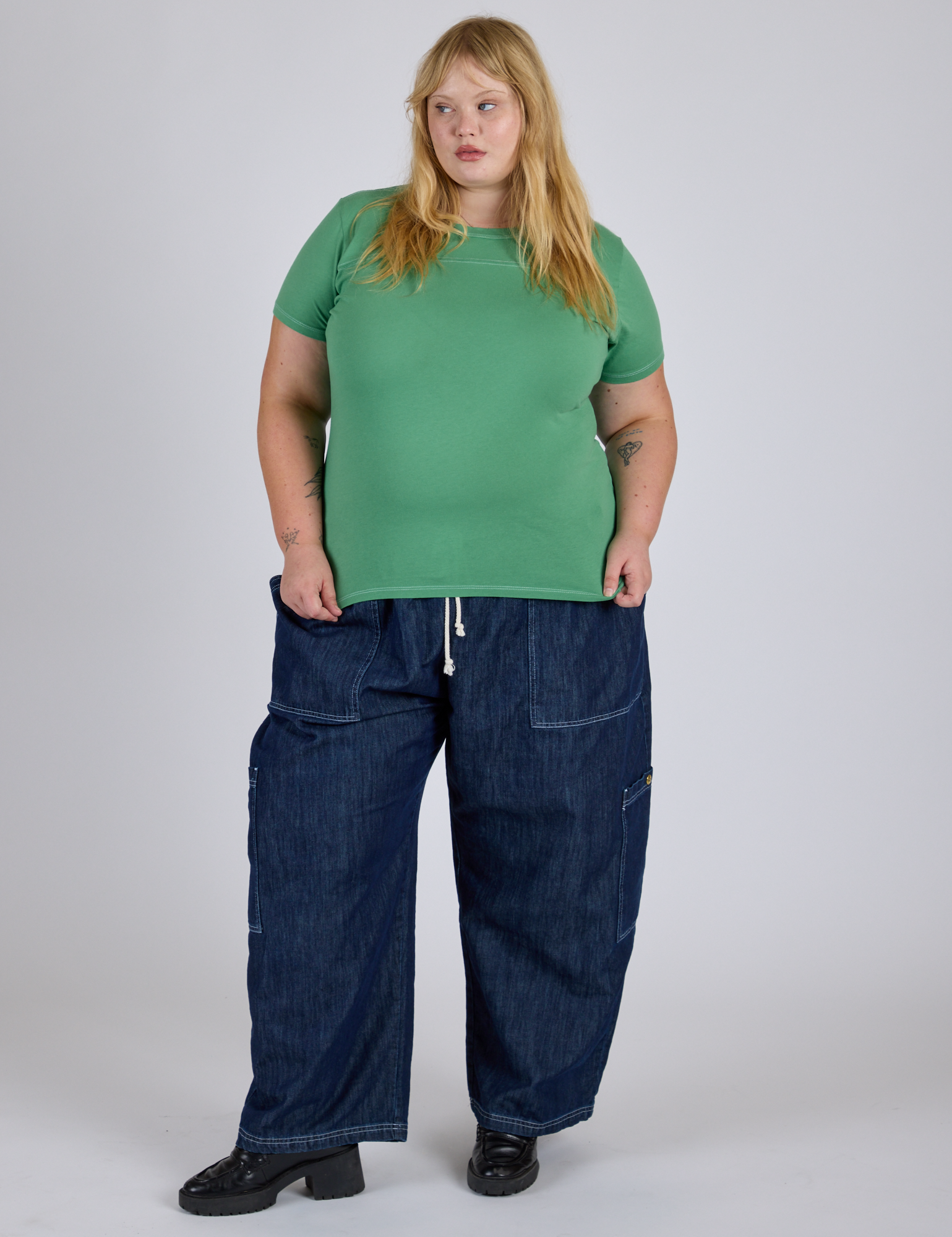 Juliet is 5’7” and wearing L Jr. Varsity Tee in Seafoam Green paired with dark wash Denim Drop Pocket Pants