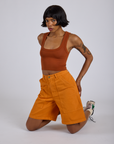 Longline Work Shorts in Creamsicle Orange and burnt terracotta Cropped Tank worn by Kira