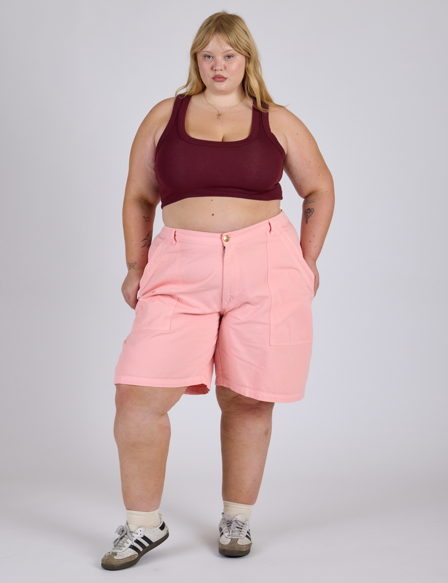 Juliet is 5’7” and wearing 2XL Longline Work Shorts in Baby Pink paired with red wine Mini Tank