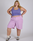 Juliet is 5’7” and wearing 2XL Longline Work Shorts in Lilac Purple paired with faded grape Cropped Tank