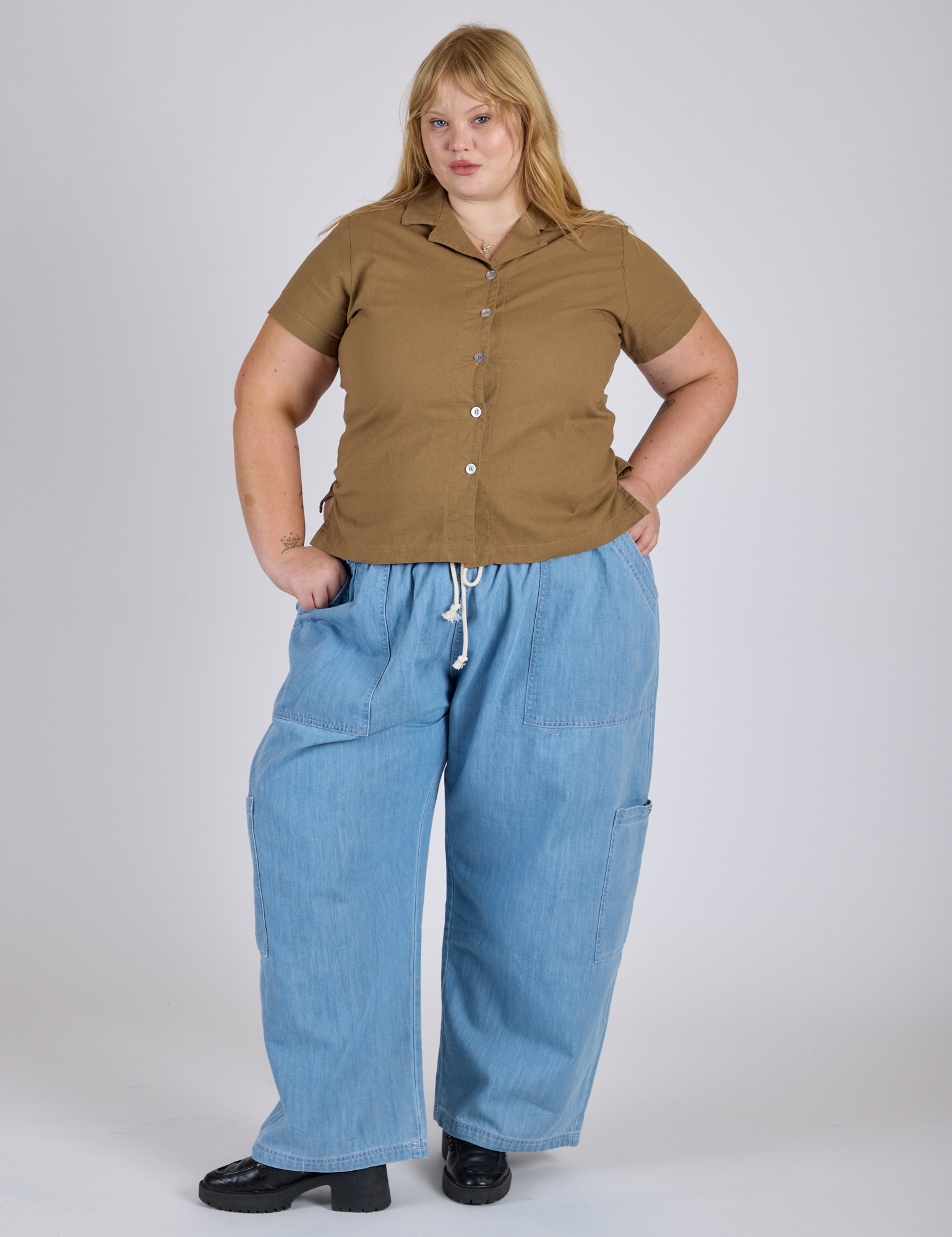 Juliet is 5’7” and wearing L Pantry Button-Up in Desert Brown paired with light wash Denim Drop Pocket Pants