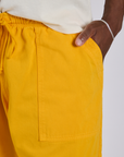 Close up of Isaac's hand in the front pocket of Drop Pocket Cargo Pants in Sunshine Yellow