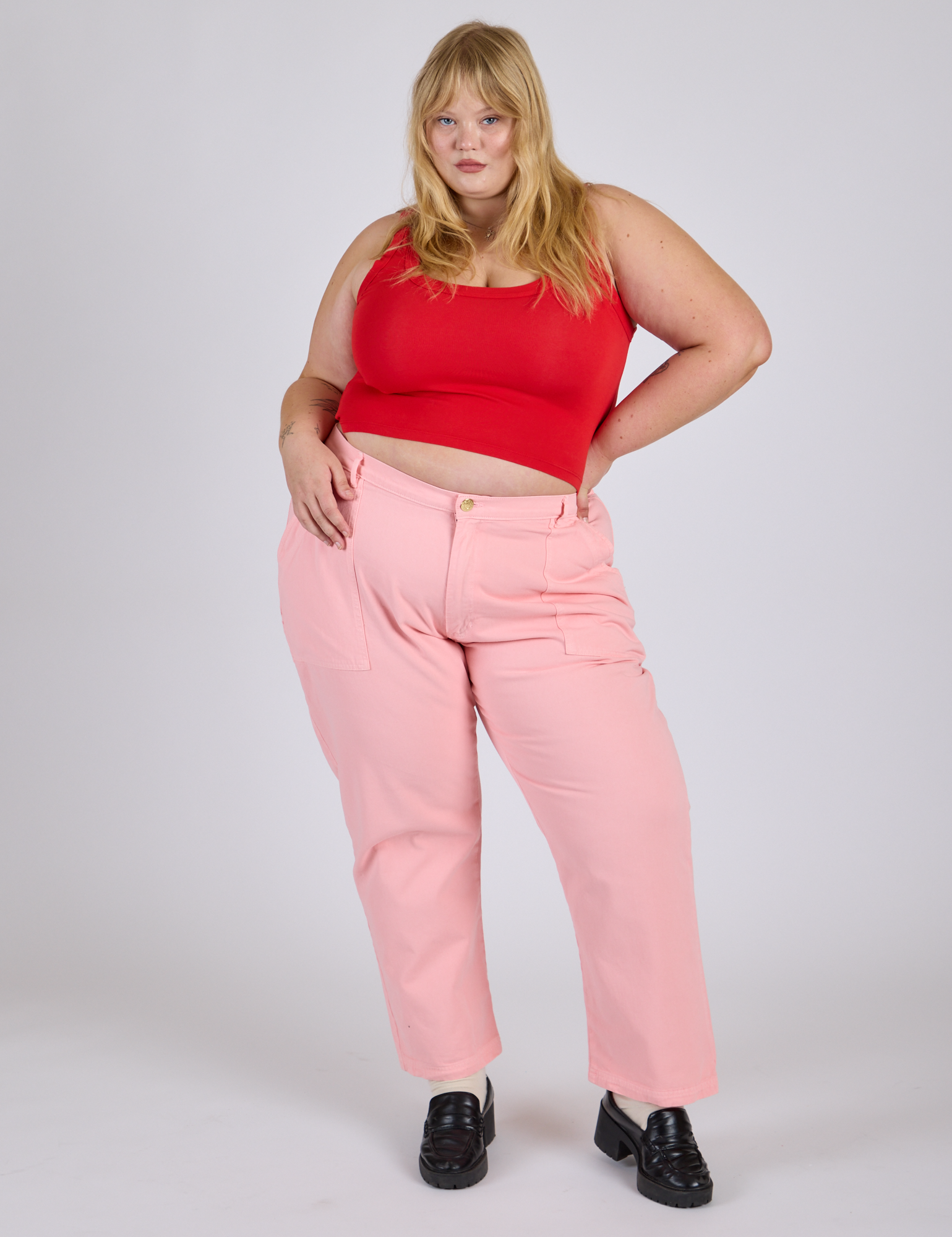 Juliet is 5’7” and wearing 2XL Work Pants in Baby Pink paired with mustang red Cropped Tank