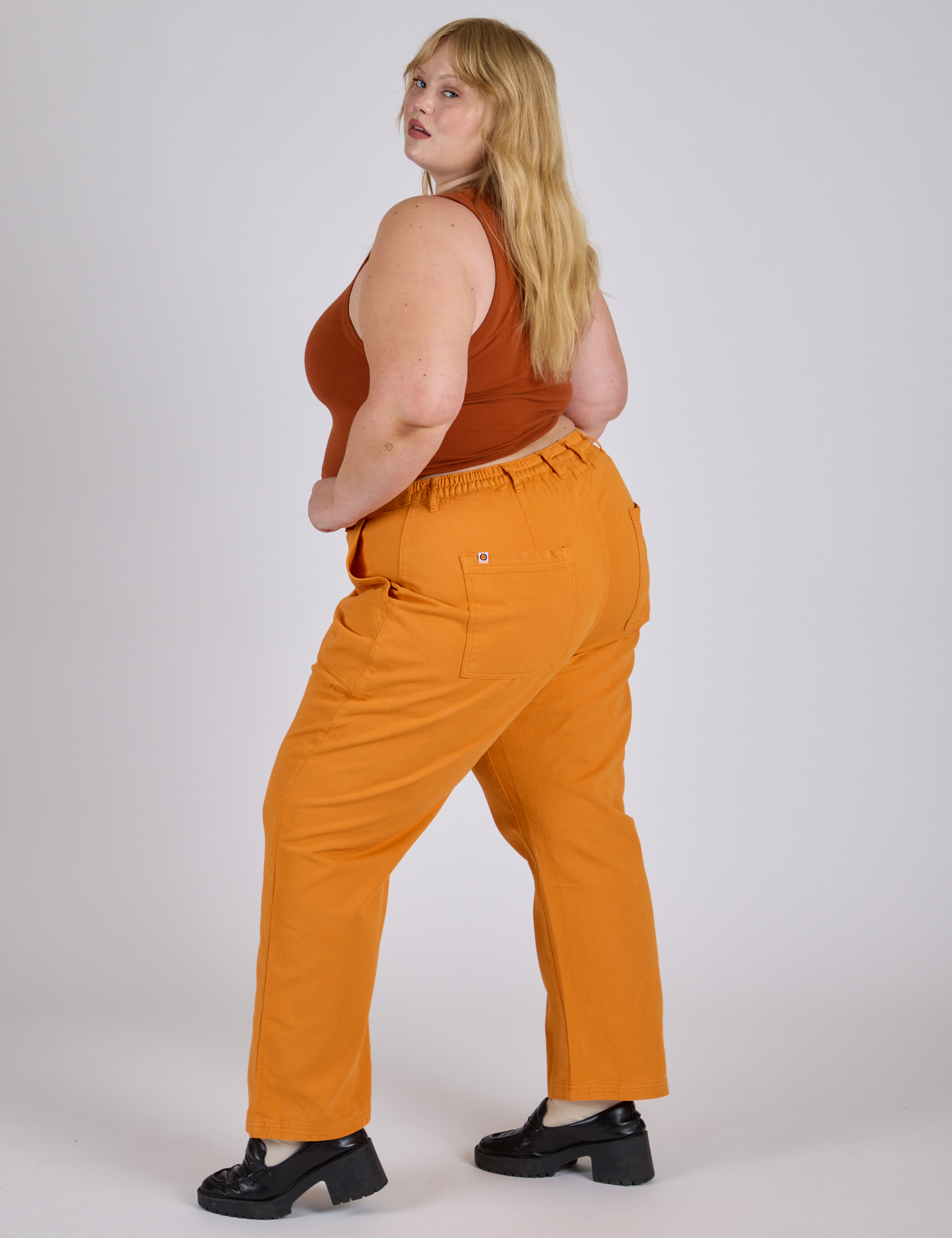 Work Pants in Creamsicle Orange side view on Juliet
