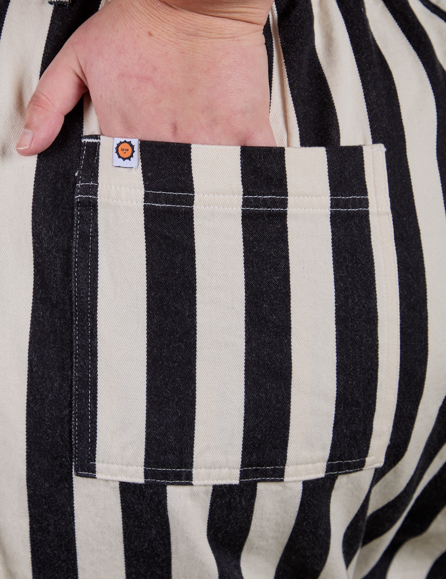 Close up of Juliet's hand in the back pocket of Longline Work Shorts in Natural